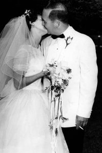 Black and white photo of a bride and a groom kissing.